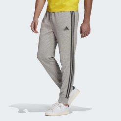 Spodnie męskie adidas ESSENTIALS 3-STRIPES. Czarne długie spodnie sportowe męskie ADIDAS, bez wzorów, z polaru. Za 163.99 zł.
