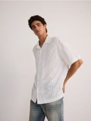 Koszula relaxed fit z bawełny - biały. Białe koszule męskie Reserved, l, bez wzorów, z bawełny, bez kołnierzyka, bez ramiączek. W wyprzedaży za 49.99 zł.