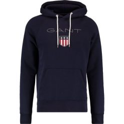GANT SHIELD HOODIE Bluza z kapturem evening blue. Bluzy nierozpinane męskie marki Gant. W wyprzedaży za 347.65 zł.