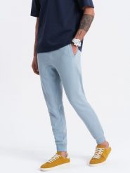 Męskie spodnie dresowe typu jogger - niebieskie V7. Niebieskie spodnie dresowe męskie Ombre Clothing, bez wzorów, z bawełny. W wyprzedaży za 101.24 zł.