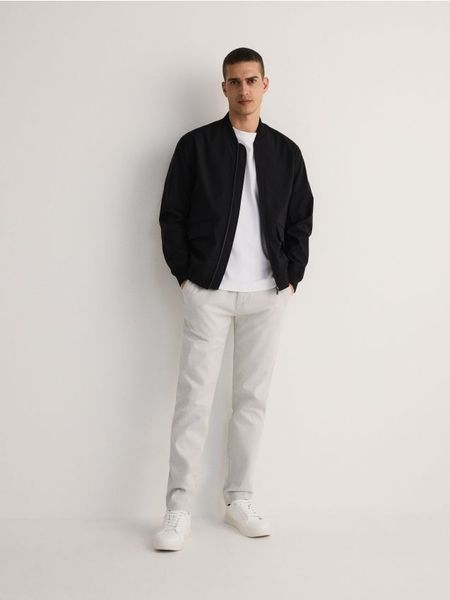 Kurtka bomberka - czarny. Czarne kurtki męskie Reserved, l, bez wzorów, z tkaniny, bez ramiączek, bez kaptura. W wyprzedaży za 59.99 zł.