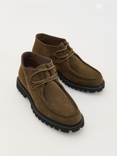 Zamszowe botki za kostkę - brązowy. Brązowe sztyblety męskie Reserved, ze skóry, za kostkę, bez obcasa, bez zapięcia. W wyprzedaży za 99.99 zł.