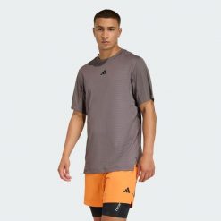 KOSZULKA D4T PrimeLift 3 STRIPES. Brązowe t-shirty sportowe męskie ADIDAS, bez wzorów, sportowe, bez ramiączek. Za 219.00 zł.