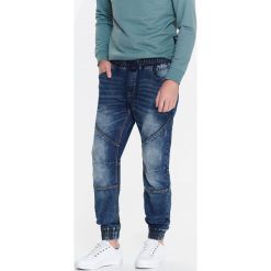 SPODNIE MĘSKIE TYPU JOGGER Z DZIANINY IMITUJĄCEJ JEANS. Spodnie na co dzień męskie marki TOP SECRET. W wyprzedaży za 119.99 zł.