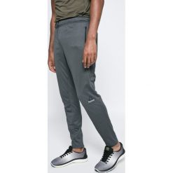 Reebok - Spodnie. Szare długie spodnie sportowe męskie marki Reebok, z dzianiny. W wyprzedaży za 159.90 zł.