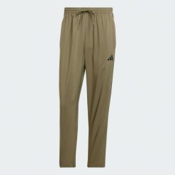 Spodnie Essentials 3-Stripes Stanford Open Hem. Brązowe spodnie dresowe męskie ADIDAS, bez wzorów, z materiału. Za 179.00 zł.