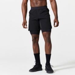 Spodenki fitness cardio męskie Domyos 2 w 1. Czarne szorty sportowe męskie DOMYOS, bez wzorów, z elastanu, sportowe. Za 89.99 zł.