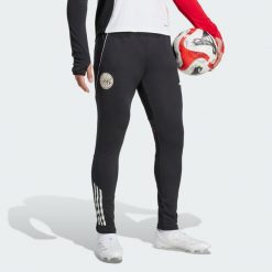 Spodnie treningowe Ajax Amsterdam Tiro 25 Competition. Białe długie spodnie sportowe męskie ADIDAS, bez wzorów, na fitness i siłownię. Za 279.00 zł.