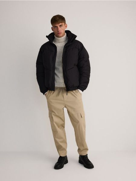 Pikowana kurtka ze stójką - czarny. Czarne kurtki męskie Reserved, l, bez wzorów, z tkaniny, bez ramiączek, bez kaptura. W wyprzedaży za 59.99 zł.