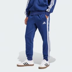 Spodnie Essentials 3-Stripes Fleece. Białe długie spodnie sportowe męskie ADIDAS, bez wzorów, z materiału, na fitness i siłownię. Za 171.99 zł.
