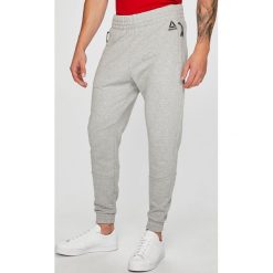 Reebok - Spodnie. Szare długie spodnie sportowe męskie marki Reebok, z bawełny. W wyprzedaży za 239.90 zł.