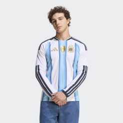 Argentina 26 Home Replica Koszulka z długim rękawem. Białe koszulki męskie z długim rękawem ADIDAS, bez wzorów, sportowe, bez kołnierzyka, bez ramiączek. Za 479.00 zł.