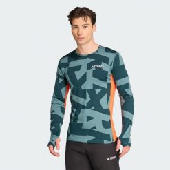 Koszulka z długim rękawem Multi Synthetic Base Layer. Niebieskie koszulki męskie z długim rękawem ADIDAS, uniwersalny, bez wzorów, sportowe, bez kołnierzyka, bez ramiączek. W wyprzedaży za 142.35 zł.