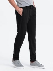 Męskie spodnie dresowe o marchewkowym kroju - czarne V1. Czarne spodnie dresowe męskie Ombre Clothing, bez wzorów, z dresówki. W wyprzedaży za 99.99 zł.