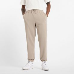 Spodnie męskie New Balance MP41519ADS – beżowe. Brązowe spodnie dresowe męskie New Balance, bez wzorów, z bawełny. Za 249.99 zł.