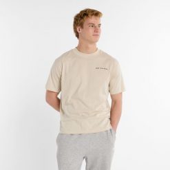 Koszulka męska New Balance MT51507TWF – beżowa. Brązowe t-shirty sportowe męskie New Balance, l, bez wzorów, z bawełny, klasyczne, bez ramiączek. Za 89.99 zł.