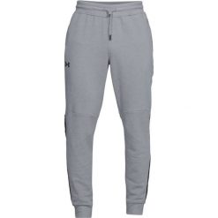 Spodnie dresowe w kolorze szarym. Szare długie spodnie sportowe męskie Under Armour, bez wzorów, z dresówki. W wyprzedaży za 179.95 zł.
