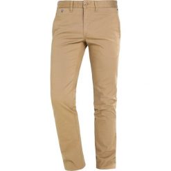 Tommy Jeans SLIM FERRY Chinosy beige. Brązowe eleganckie spodnie męskie Tommy Jeans, z bawełny. Za 379.00 zł.