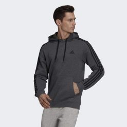 Bluza męska adidas Essentials Fleece 3-Stripes Hoodie. Czarne bluzy nierozpinane męskie ADIDAS, m, bez wzorów, z bawełny, sportowe, bez ramiączek, z kapturem. Za 194.00 zł.