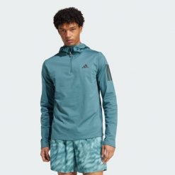 Bluza z kapturem Own The Run Winterized Hooded Half-Zip. Niebieskie bluzy z kapturem męskie ADIDAS, bez wzorów, bez zapięcia, do biegania, ClimaWarm (Adidas). Za 279.99 zł.