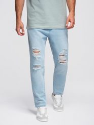 Spodnie jeansowe męskie CARROT FIT z przetarciami – jasnoniebieskie V1 - Rozmiar: XXL. Niebieskie spodnie na co dzień męskie Ombre Clothing, z aplikacjami, z bawełny, klasyczne. W wyprzedaży za 191.99 zł.